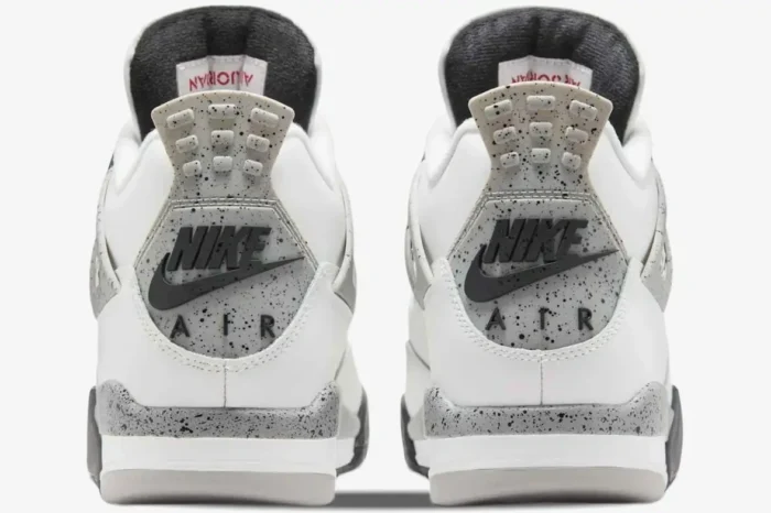Rear view of Air Jordan 4 Retro White Cement sneakers featuring grey speckled heel tabs with black Nike Air branding. - SKU 840606-192