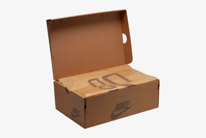 Open brown Nike Air Max 1 x Cactus Jack shoe box with branded tissue paper, three-quarter view. - SKU DO9392-200