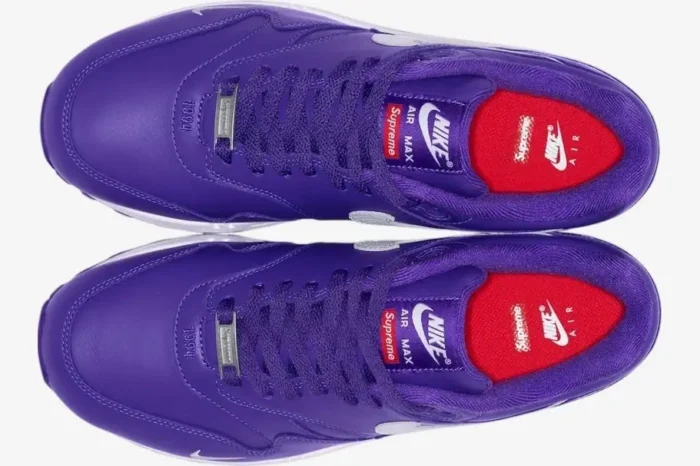 Top-down view of purple Nike Air Max 1 x Supreme sneakers with white accents and red insoles. - SKU HF8813-500