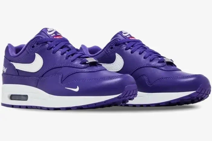 Nike Air Max 1 x Supreme purple leather sneakers with white swoosh, side-angled view. - SKU HF8813-500