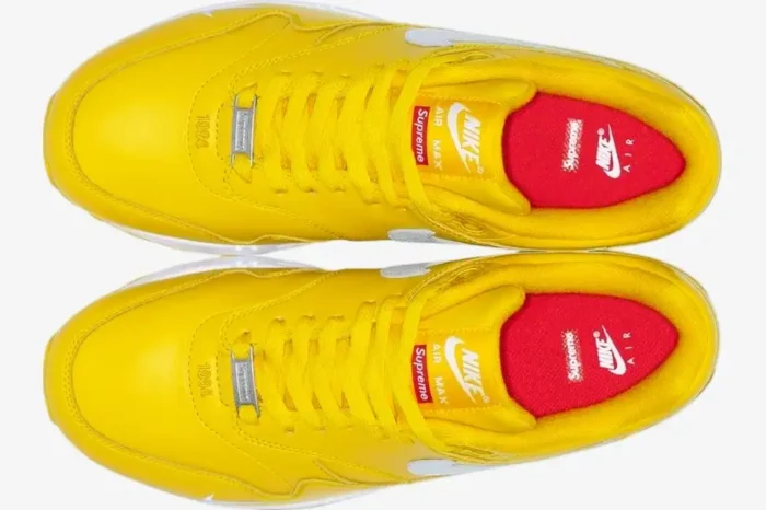 Top-down view of yellow Nike Air Max 1 x Supreme sneakers with white Swooshes and red insoles. - SKU HF8813-700