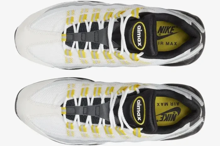 Top-down view of Nike Air Max 95 Tour sneakers in white, grey, and yellow with white laces and yellow insoles. - SKU 609048-105