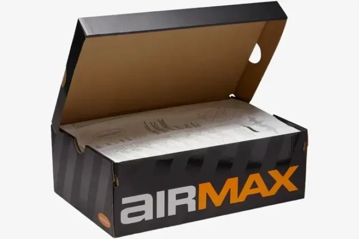 Open black and orange Nike Air Max shoebox with tissue paper inside, angled front view. - SKU HQ4681-010