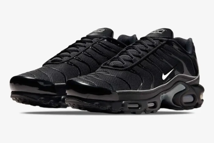 Three-quarter view of Nike Air Max Plus Black Reflective sneakers in all-black colorway. - SKU 604133-050
