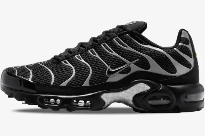 Side profile of Nike Air Max Plus sneakers in black with reflective silver wavy overlays and visible air units. - SKU HQ3029-001