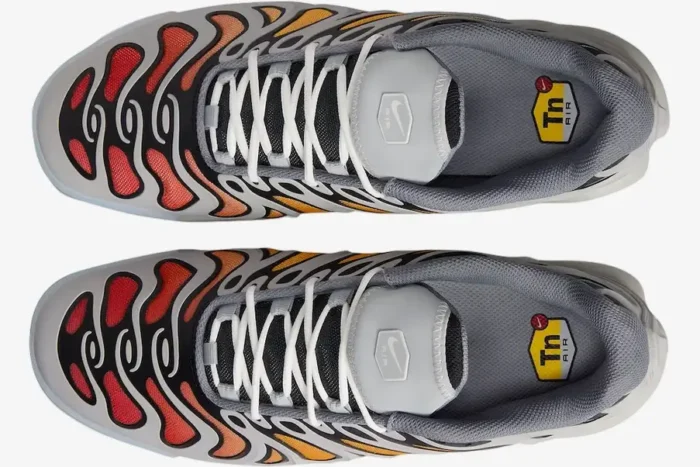Top-down view of Nike Air Max Plus Drift sneakers in smoke grey featuring an orange and red gradient mesh. - SKU FD4290-002