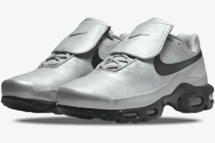 A pair of silver Nike Air Max Plus Tiempo shoes with black soles and swoosh, angled view. - SKU HM6850-001