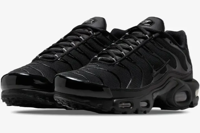Three-quarter front view of Nike Air Max Plus TN sneakers in a sleek triple black colorway. - SKU DM2362-002