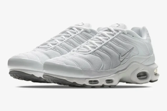 Nike Air Max Plus Triple White sneakers in a three-quarter front view against a white background. - SKU 604133-139