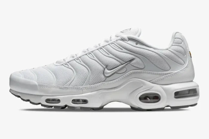 Side profile of Nike Air Max Plus Triple White sneakers with visible Air units and mesh upper. - SKU 604133-139