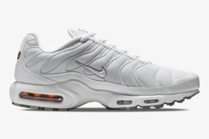 Side profile of Nike Air Max Plus Triple White sneakers featuring a mesh upper and silver swoosh. - SKU 604133-139