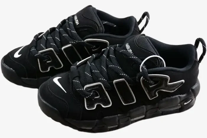 Black and white Nike Air More Uptempo Low x AMBUSH sneakers shown from a three-quarter front angle. - SKU FB1299-001