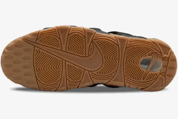Bottom view of a Nike Air More Uptempo Low shoe featuring a textured gum rubber outsole with Nike branding. - SKU FZ3055003