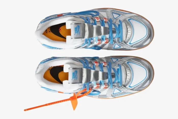 Top-down view of Nike Air Rubber Dunk x Off-White University Blue sneakers with silver overlays and orange zip tie. - SKU CU6015-100