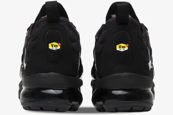 Rear view of Nike Air Vapormax Plus Triple Black sneakers featuring the iconic Vm Air heel logo and black air unit. - SKU 924453-004