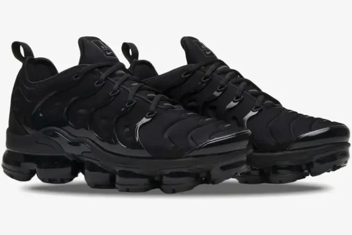 Nike Air Vapormax Plus Triple Black sneakers shown from a three-quarter side angle. - SKU 924453-004