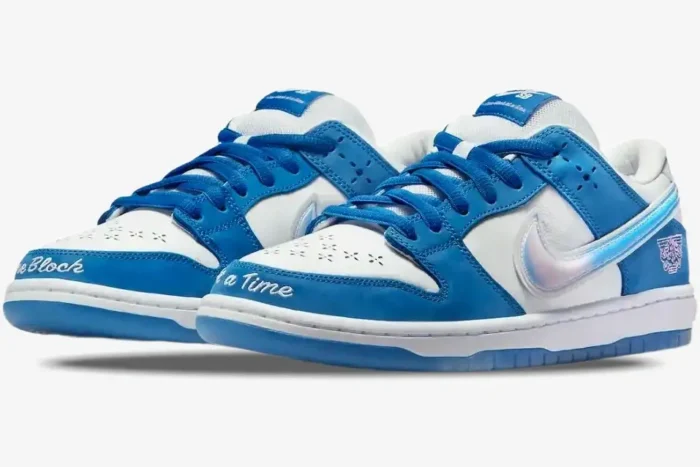 Blue and white Nike Dunk Low x Born x Raised sneakers, three-quarter front view with iridescent swoosh. - SKU FN7819-400