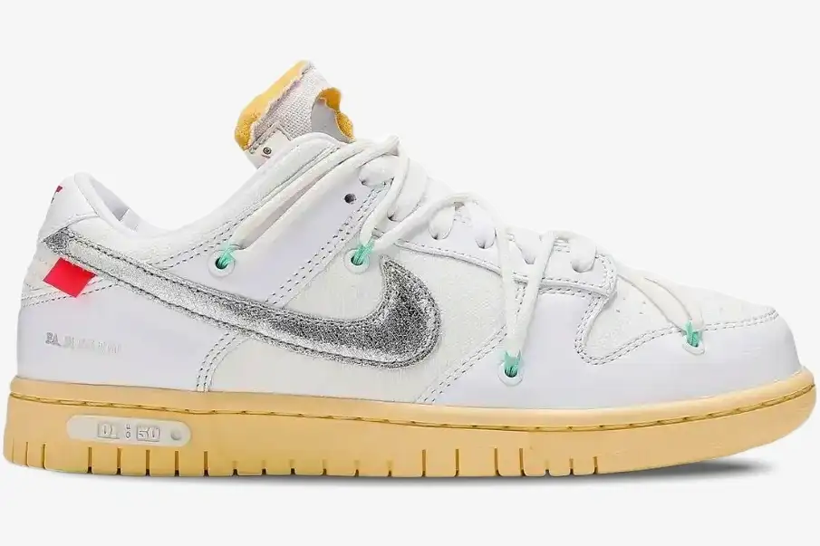 nike-dunk-low-off-white-lot-01-side-view-dm1602-127-img2724 Side view of Nike Dunk Low x Off-White Lot 01 of 50 sneaker in white with a metallic silver swoosh and cream sole. - SKU DM1602-127