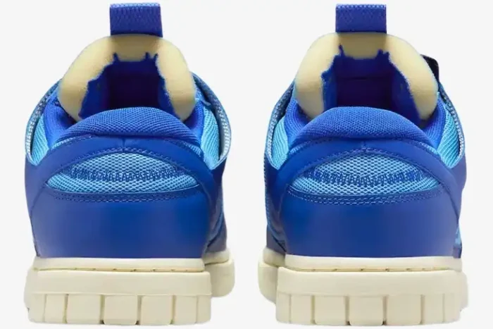 Rear view of Nike Dunk Low Remastered Jumbo Blue sneakers featuring exposed foam tongues and cream soles. - SKU DV0821-400