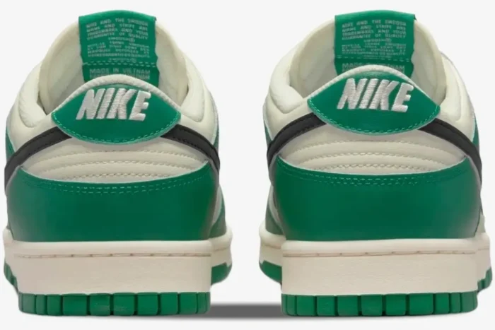 Rear view of Nike Dunk Low SE Lottery Malachite Green sneakers showing green heel tabs and sail midsoles. - SKU DR9654-100