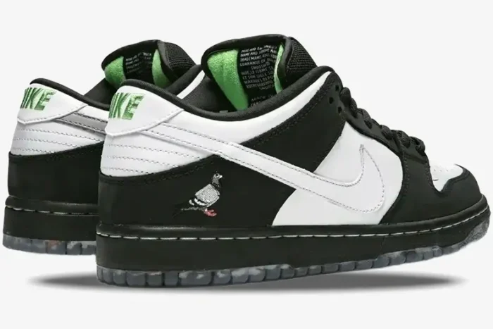 Rear-side view of Nike SB Dunk Low x Staple Panda Pigeon sneakers in black and white with green accents. - SKU BV1310-013