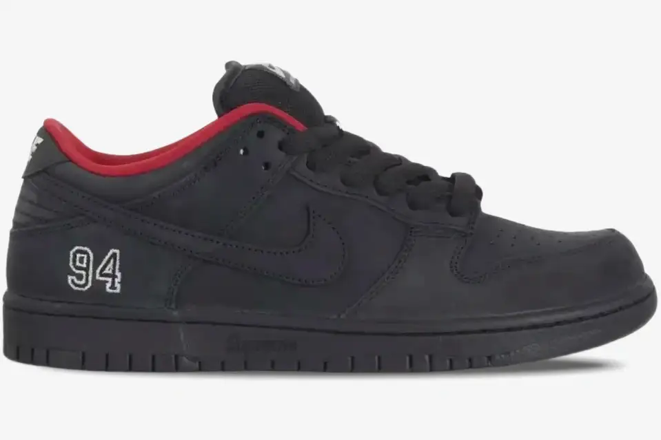nike-sb-dunk-low-supreme-black-94-side-view-hq8487001 Side profile of Nike SB Dunk Low x Supreme in black with red lining and '94' heel embroidery. - SKU HQ8487001