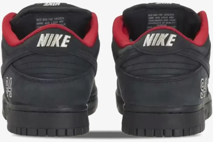 Rear view of black Nike SB Dunk Low Supreme sneakers with red lining and '94' embroidery. - SKU HQ8487001