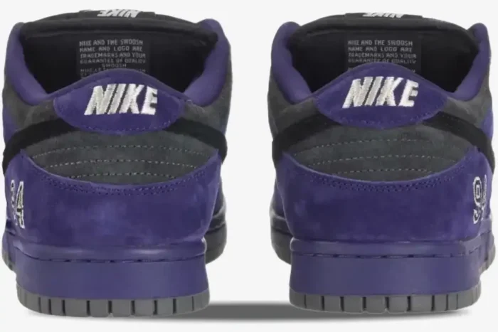 Rear view of Nike SB Dunk Low x Supreme sneakers in purple suede with white NIKE embroidery on the heel. - SKU HQ8487500