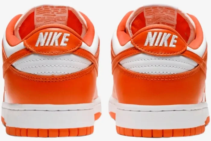 Rear view of Nike SB Dunk Low Syracuse sneakers in orange and white with white NIKE heel embroidery. - SKU CU1726-101