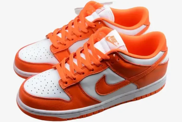 Nike SB Dunk Low Syracuse sneakers in orange and white, three-quarter perspective of the pair. - SKU CU1726-101