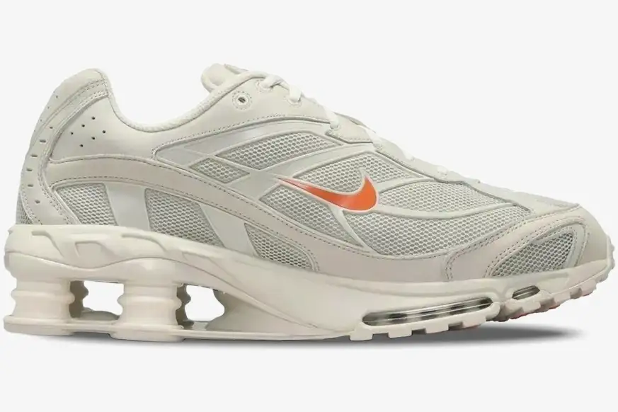 nike-shox-ride-2-cream-orange-side-view-dj5415-100 Side profile of a Nike Shox Ride 2 sneaker in cream with an orange swoosh and visible heel columns. - SKU DJ5415-100