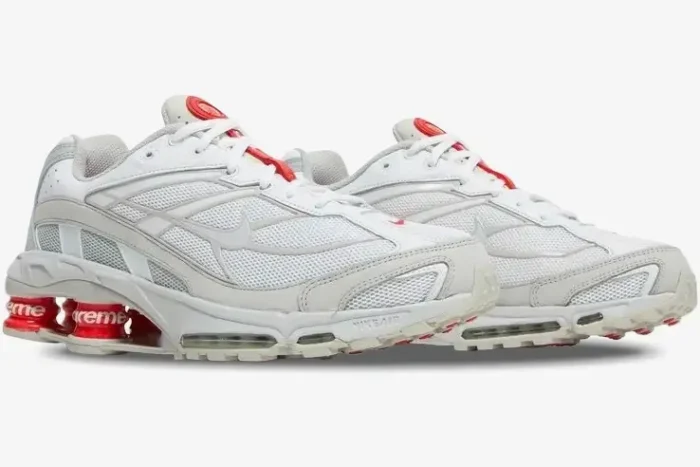 Side view of Nike Shox Ride 2 x Supreme sneakers in white and red with visible Shox pillars. - SKU DN1615-100