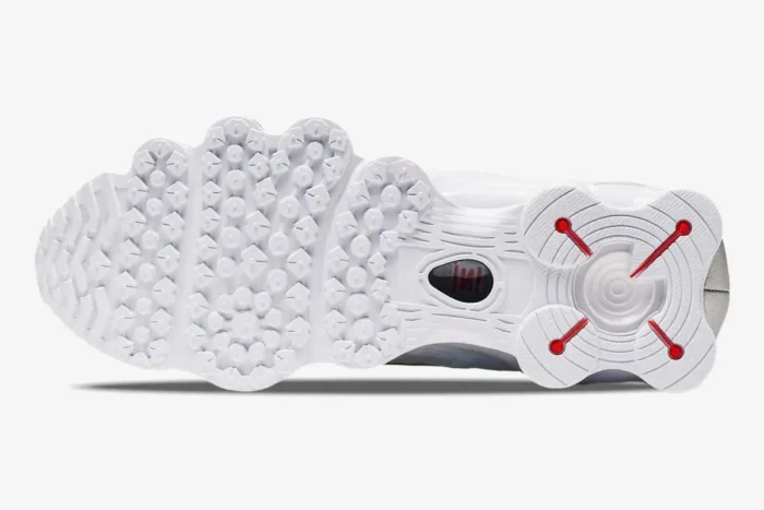Bottom view of the Nike Shox TL White Metallic Silver outsole featuring white traction pods and red accents. - SKU AV3595-100
