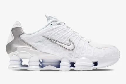Side profile of Nike Shox TL sneakers in white and metallic silver featuring full-length cushioning columns. - SKU AV3595-100