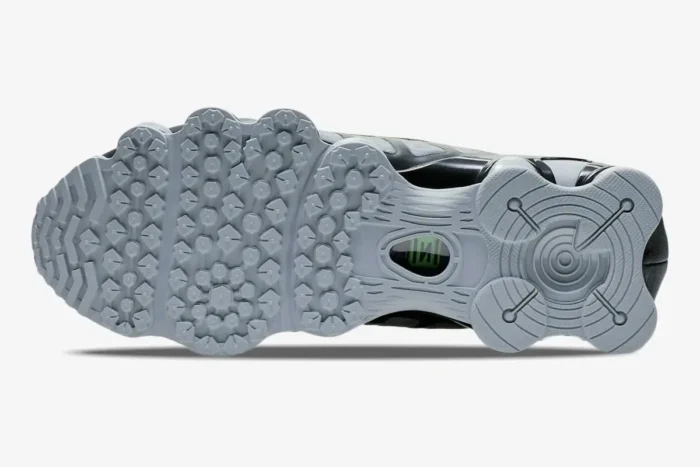 Underside view of Nike Shox TL Wolf Grey Lime Blast sneakers showing the grey textured outsole and green logo. - SKU AV3595-005