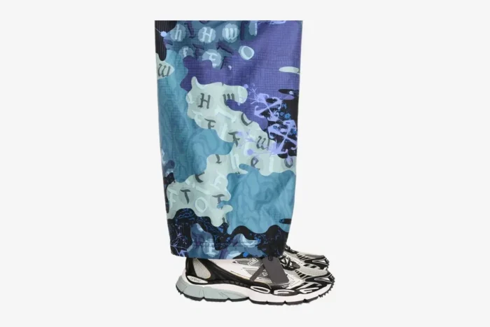 Side view of Off-White Be Right Back sneakers in black, white, and grey, worn with patterned blue pants. - SKU OMIA295C99FAB0010510