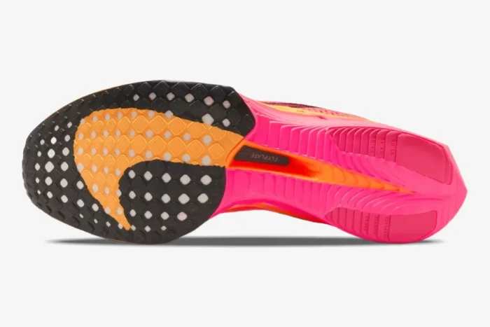 Outsole view of the Nike ZoomX Vaporfly 3 in pink and orange, showing the tread and Flyplate. - SKU DV4129-600