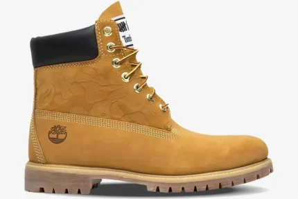 Side profile of a Timberland x BAPE x Undefeated 6-inch wheat boot with embossed camo patterns. - SKU TB0A1R7Y231