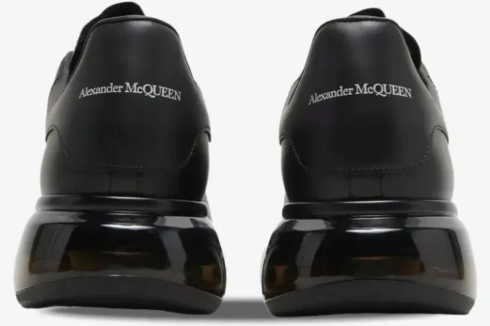 Rear view of Alexander McQueen Oversized sneakers in black leather with a chunky transparent sole. - SKU 604232-WHX98-1000
