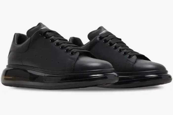 Alexander McQueen Oversized sneakers in black leather with a transparent sole, three-quarter view. - SKU 604232-WHX98-1000