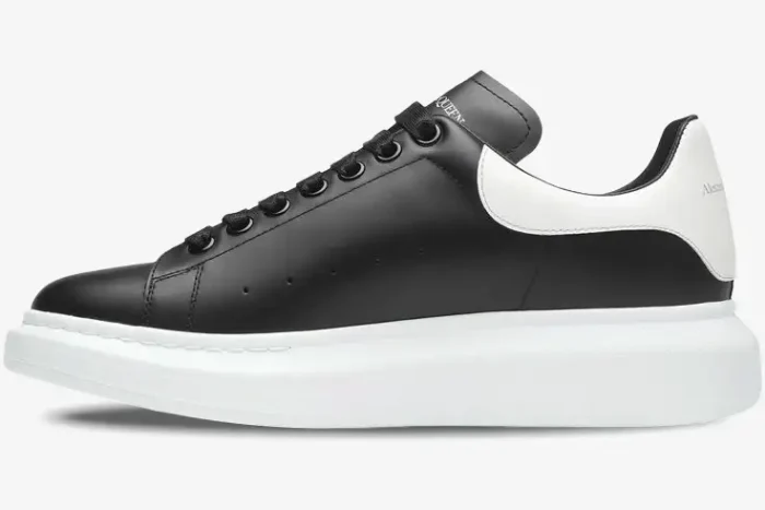 Side profile of the Alexander McQueen Oversized Sneaker in black leather with a chunky white sole. - SKU 553680-WHGP5-1070