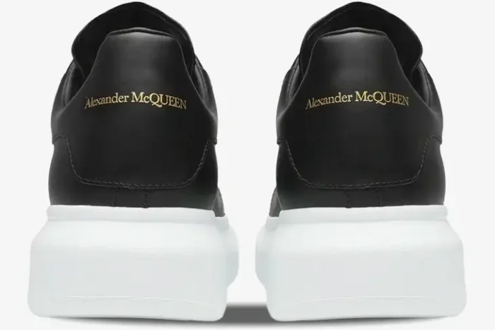 Rear view of black Alexander McQueen Oversized Sneakers with gold logo and chunky white soles. - SKU 553680WHGP51000