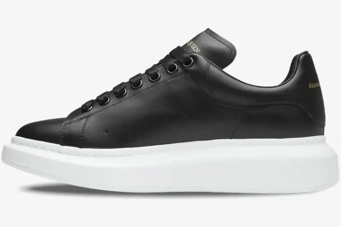 Side profile of Alexander McQueen Oversized Sneaker in black leather with a chunky white sole. - SKU 553680WHGP51000