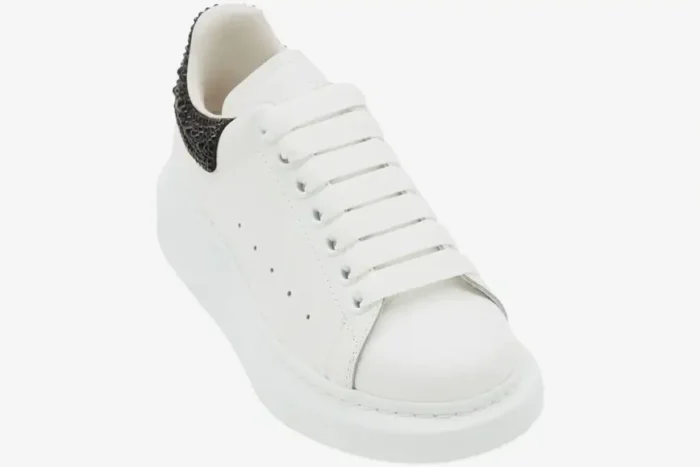 White Alexander McQueen Oversized Sneaker with black glitter heel tab, three-quarter angle view. - SKU 666407WIAIJ9581