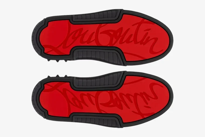 Bottom view of Christian Louboutin Astroloubi sneakers showing red signature script soles and black spiked rubber trim. - SKU 3230886H358