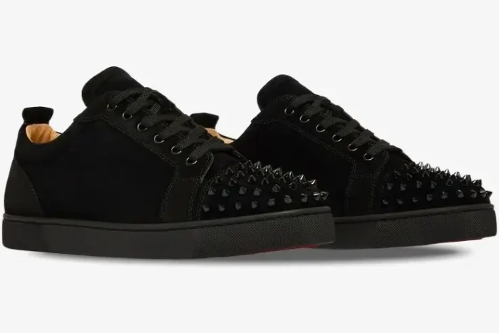 A pair of black Christian Louboutin Louis Junior Spikes Flat sneakers shown from a side angle. - SKU 1130575