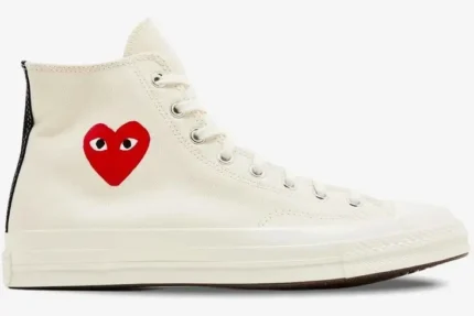 Side view of a cream Converse x CDG Play high-top sneaker featuring a red heart logo. - SKU A08800C