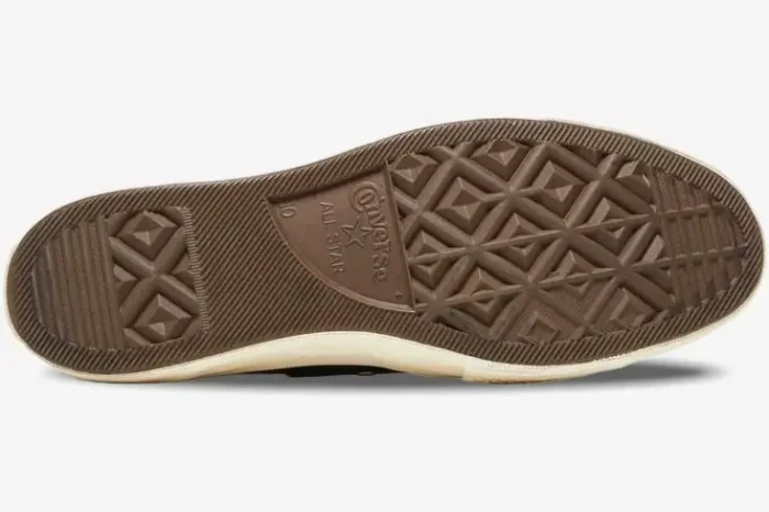 Bottom sole view of Converse x CDG Play Chuck 70 sneakers in black, featuring a brown rubber tread pattern. - SKU 150204C