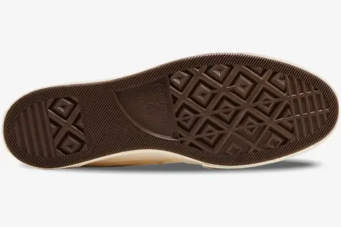 Brown rubber outsole of a Converse Chuck Taylor All Star 70s x CDG Play shoe, bottom view. - SKU A08800C