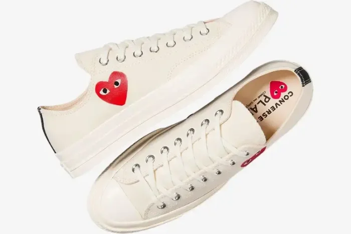 Converse x CDG Play Chuck 70 low-top white sneakers, diagonal top-down view showing red heart logo and laces. - SKU A08805C